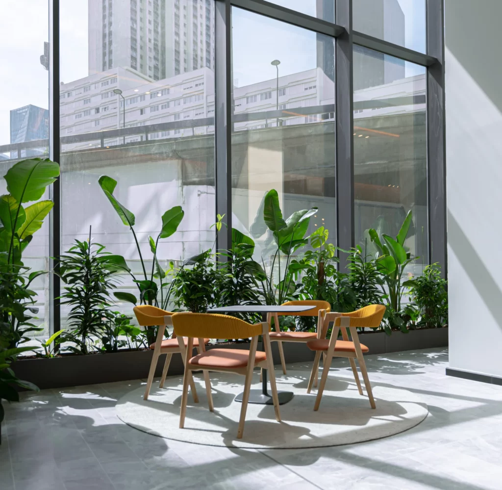 Hall d'entreprise végétalisé avec plantes vertes et vue urbaine agence paysagiste Lille et Paris